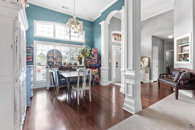 dining area featuring a notable chandelier, dark hardwood / wood-style flooring, ornate columns, and built in shelves