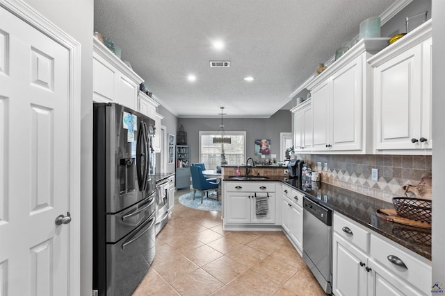 kitchen featuring white cabinets, decorative light fixtures, appliances with stainless steel finishes, and tasteful backsplash