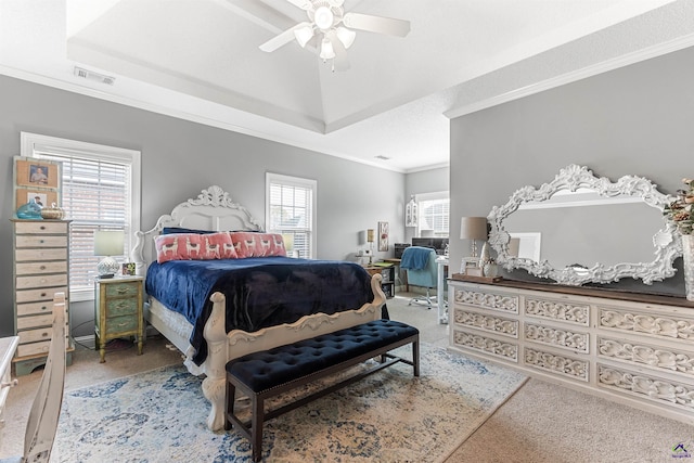 carpeted bedroom featuring a raised ceiling, ceiling fan, and ornamental molding