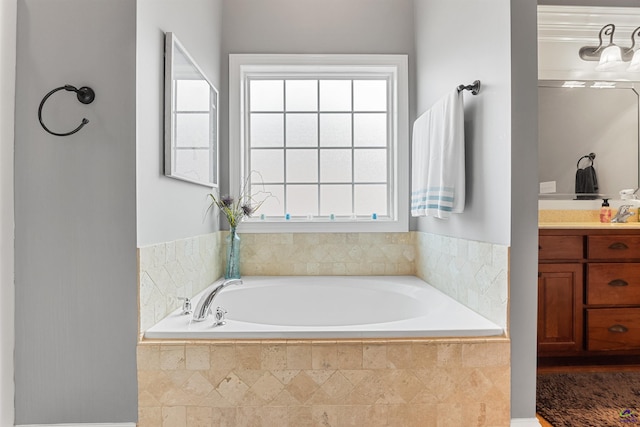 bathroom with vanity and tiled tub