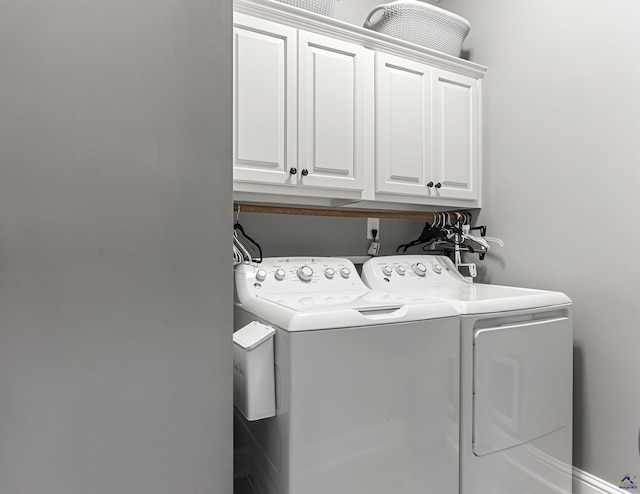 clothes washing area featuring cabinets and washing machine and dryer