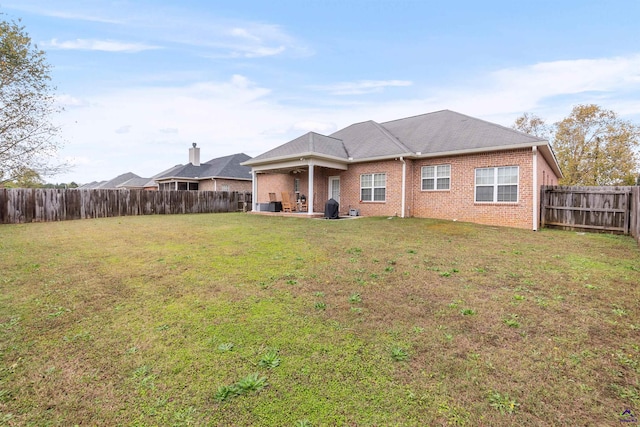 rear view of property featuring a yard and a patio