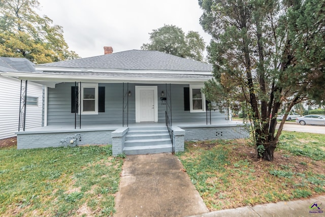 bungalow-style home with a front lawn and covered porch