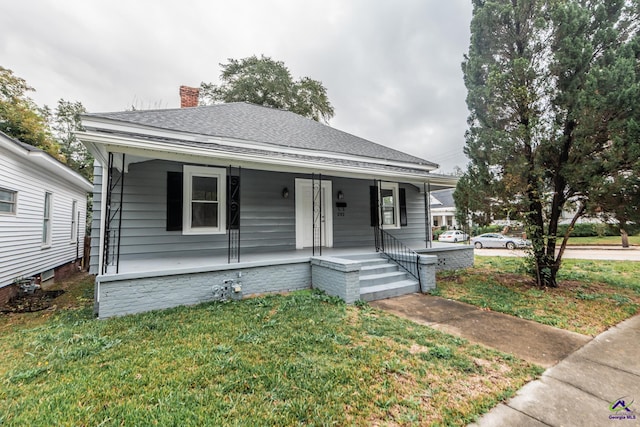 bungalow with covered porch and a front yard