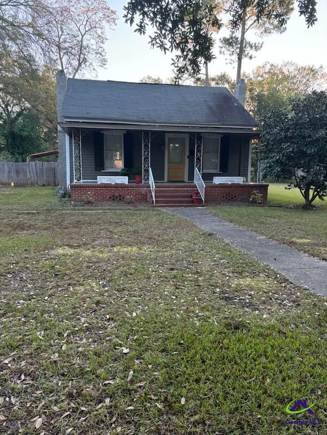 view of front of property with covered porch and a front yard