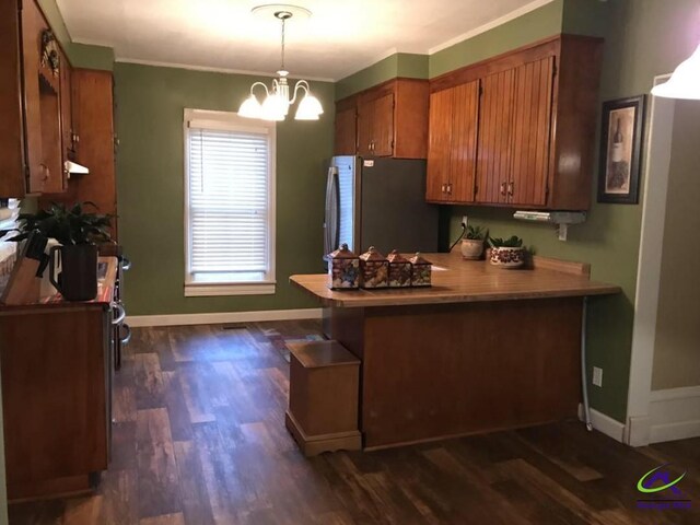 210 Anderson Ave, Fort Valley, GA 31030 - kitchen with freestanding refrigerator, brown cabinets, a chandelier, dark wood-style floors, and a peninsula