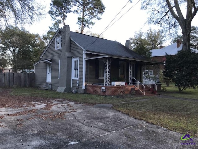 bungalow featuring a porch and a front lawn