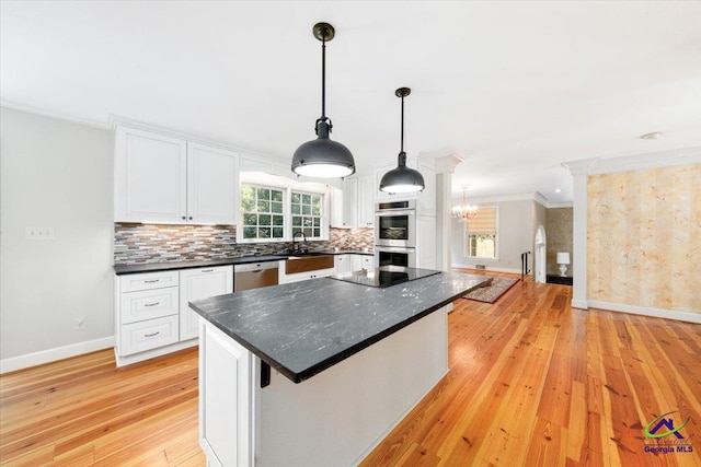 kitchen with white cabinetry, ornamental molding, hanging light fixtures, a kitchen island, and light wood-type flooring