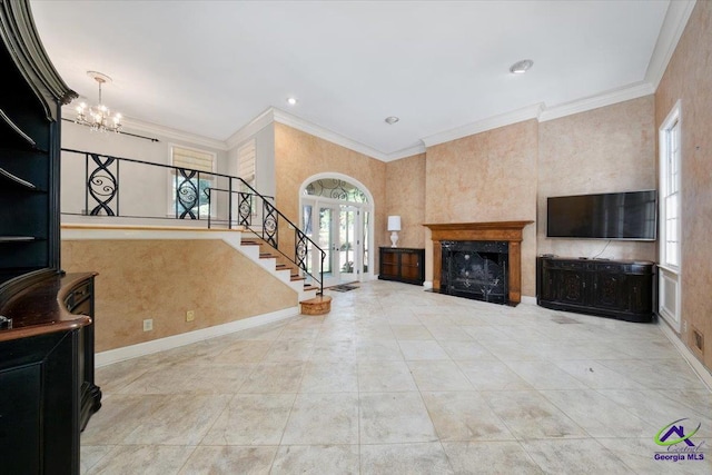 living room featuring a premium fireplace, an inviting chandelier, and ornamental molding