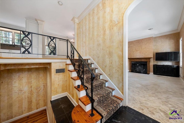 stairs with ornamental molding and hardwood / wood-style flooring