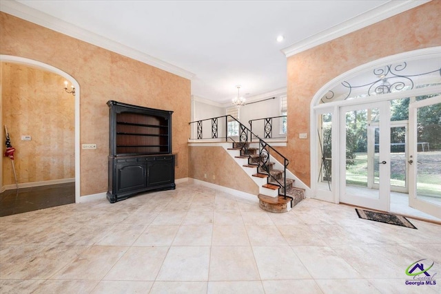 foyer featuring ornamental molding, french doors, a notable chandelier, and light tile patterned flooring