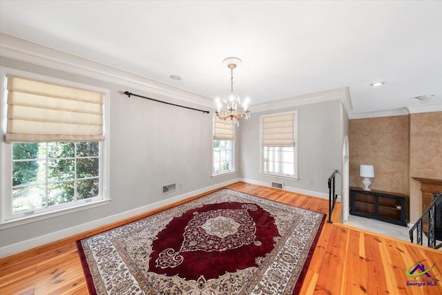 dining space with hardwood / wood-style floors, a wealth of natural light, and a chandelier