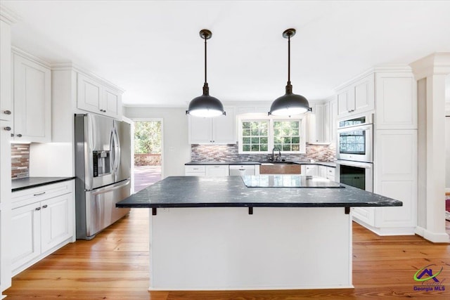 kitchen featuring stainless steel appliances, a kitchen island, light hardwood / wood-style flooring, and plenty of natural light