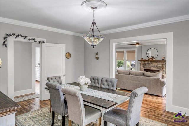 505 Engram St, Montezuma, GA 31063 - dining space with crown molding, wood finished floors, and a stone fireplace