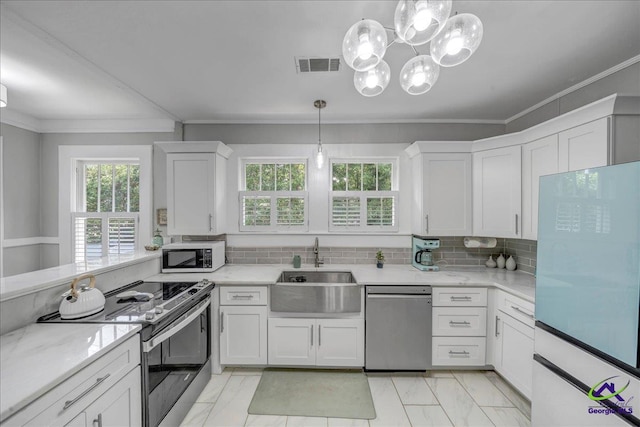 505 Engram St, Montezuma, GA 31063 - kitchen featuring stainless steel appliances, ornamental molding, white cabinets, tasteful backsplash, and a chandelier