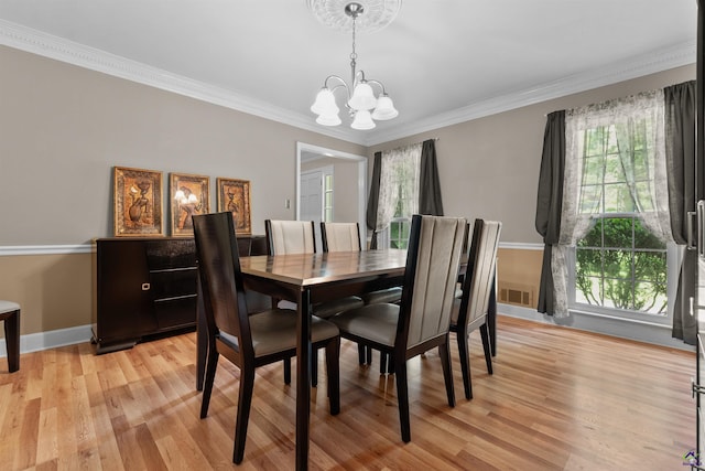 dining room with crown molding, light hardwood / wood-style flooring, and an inviting chandelier