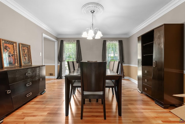 dining space with a notable chandelier, light wood-type flooring, and crown molding