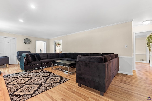 living room featuring light hardwood / wood-style flooring and crown molding