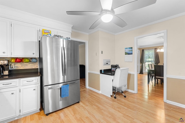 kitchen featuring stainless steel refrigerator, white cabinetry, light hardwood / wood-style floors, decorative backsplash, and ornamental molding