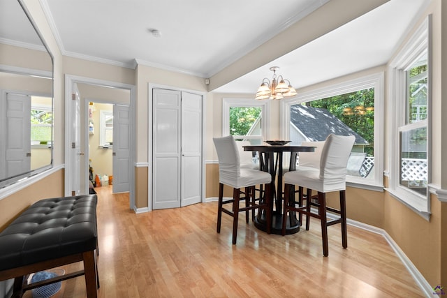 dining area with a notable chandelier, light hardwood / wood-style floors, ornamental molding, and a wealth of natural light