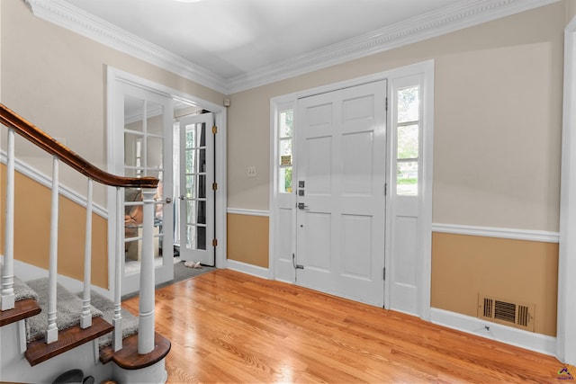 entryway featuring light wood-type flooring and ornamental molding