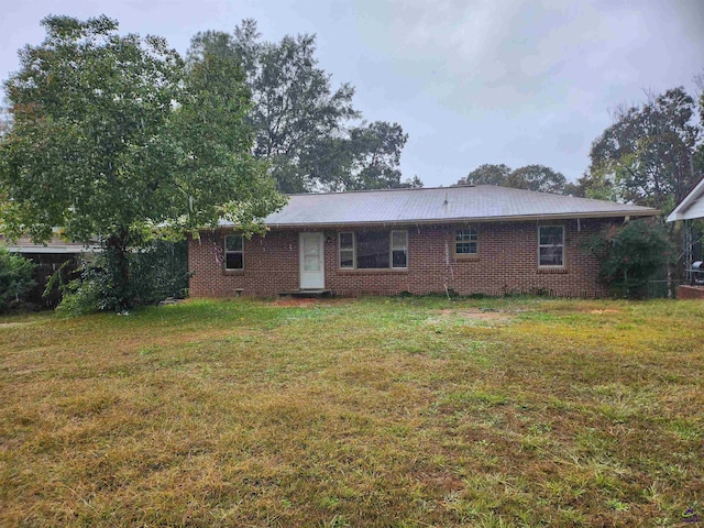 rear view of property with a lawn