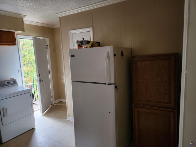 kitchen featuring a textured ceiling, white refrigerator, washer / dryer, and crown molding