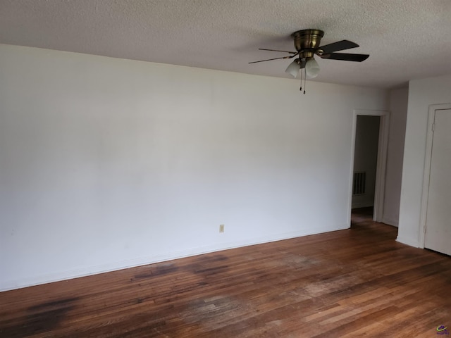 empty room with ceiling fan, dark hardwood / wood-style flooring, and a textured ceiling