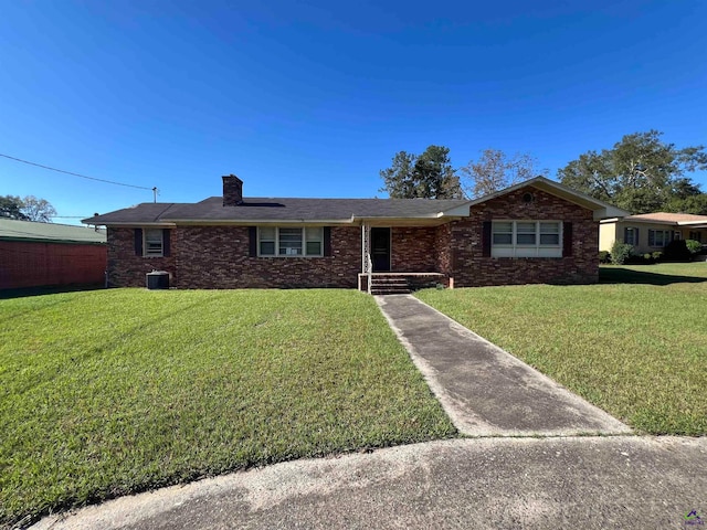 ranch-style house with central air condition unit and a front yard