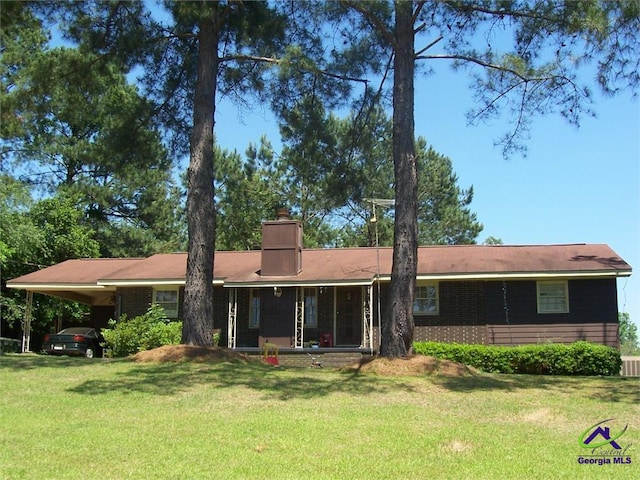 rear view of property featuring a carport and a lawn