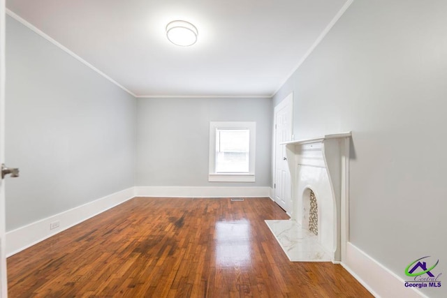 unfurnished living room featuring ornamental molding and dark wood-type flooring