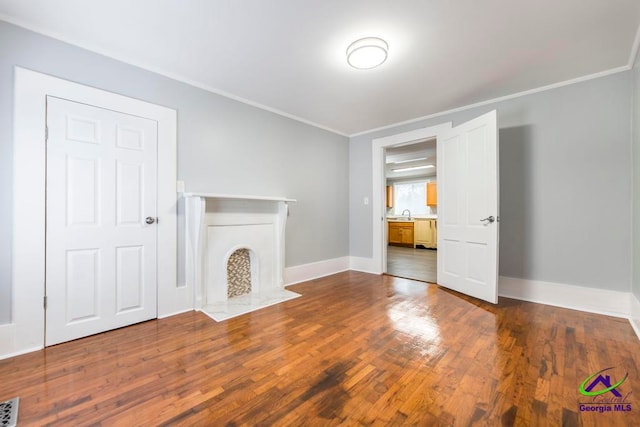 unfurnished living room featuring dark hardwood / wood-style floors and crown molding