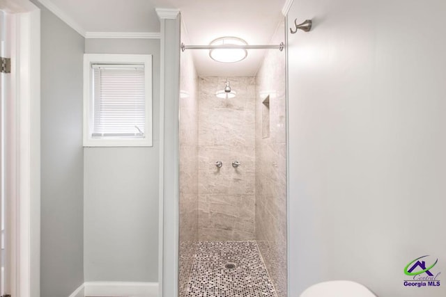 bathroom featuring a shower with shower door, toilet, and ornamental molding