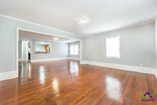 empty room featuring wood-type flooring and ornamental molding