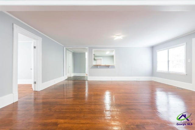 unfurnished living room featuring hardwood / wood-style floors and crown molding