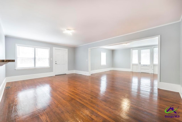 unfurnished living room with hardwood / wood-style flooring and ornamental molding