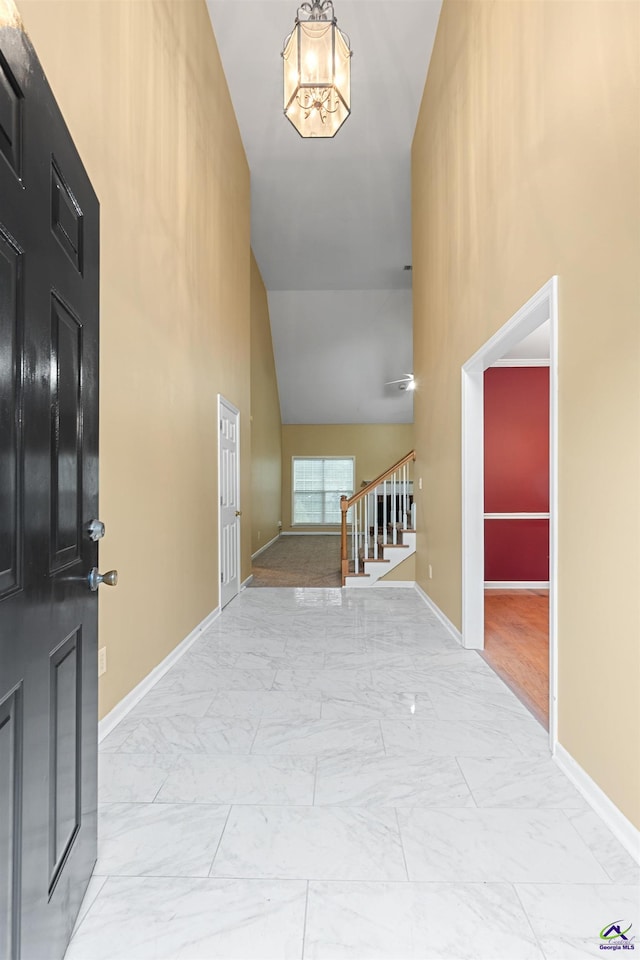 entryway featuring high vaulted ceiling and a chandelier