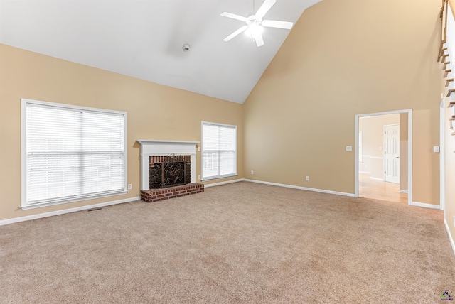 unfurnished living room featuring a brick fireplace, light colored carpet, high vaulted ceiling, and ceiling fan