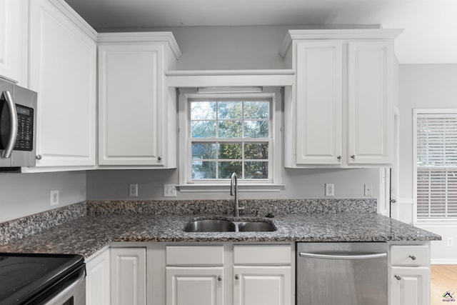 kitchen featuring dark stone counters, sink, white cabinets, and stainless steel appliances