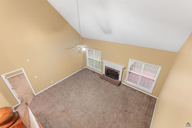 unfurnished living room with carpet, ceiling fan, high vaulted ceiling, and a brick fireplace