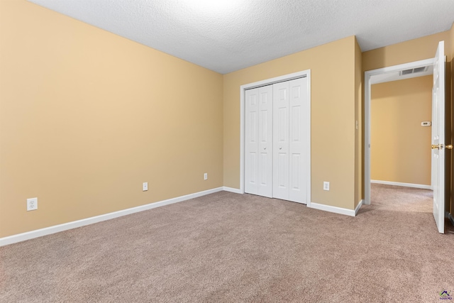 unfurnished bedroom with a closet, carpet floors, and a textured ceiling