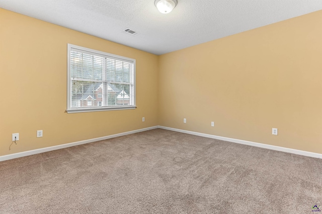 carpeted empty room featuring a textured ceiling