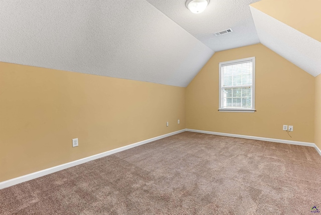 bonus room featuring carpet, a textured ceiling, and vaulted ceiling