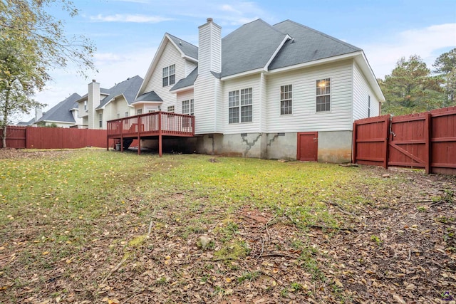 back of house featuring a deck and a lawn