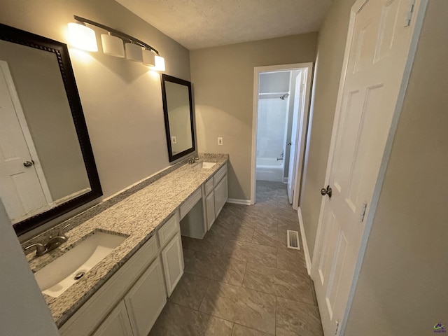 202 Lake Front Dr, Warner Robins, GA 31088 - full bath with double vanity, shower / tub combination, baseboards, and a textured ceiling