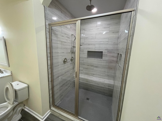 bathroom with toilet and a shower with shower door