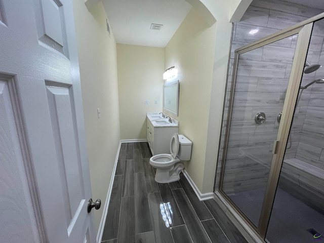 bathroom featuring vanity, toilet, and an enclosed shower