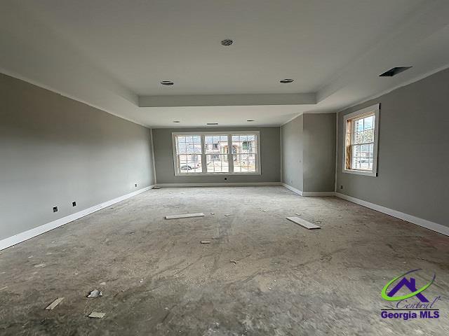 unfurnished room featuring a tray ceiling and baseboards