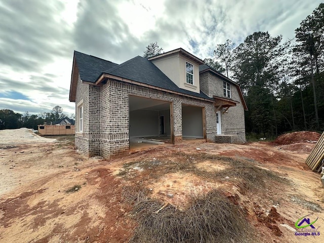 view of home's exterior featuring brick siding and a shingled roof