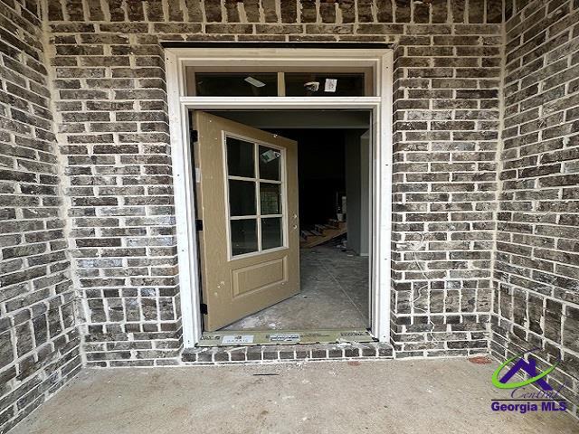 entrance to property featuring brick siding